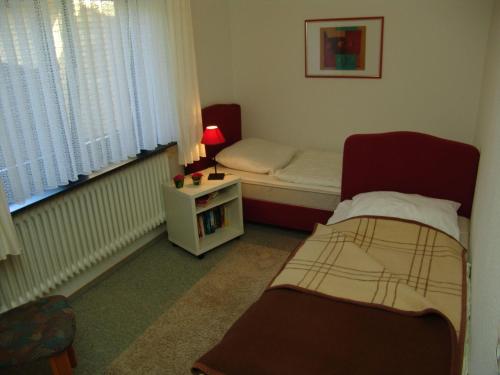 a small bedroom with two beds and a small table at Andrea-EG in Büsum