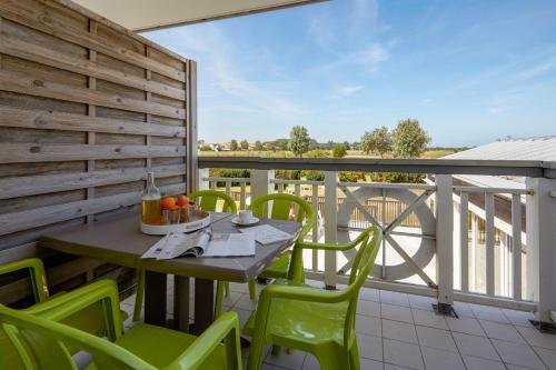a table and chairs on a balcony with a view at Pierre & Vacances Résidence Le Chant des Oiseaux in Courseulles-sur-Mer