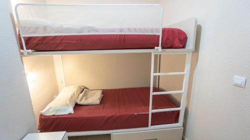 a small room with two bunk beds and a ladder at RentalSevilla Gran apartamento en Barrio Santa Cruz Parking Gratuito in Seville