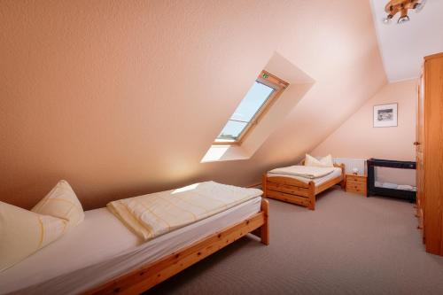 a attic room with two beds and a window at Ferienzentrum Yachthafen Rechlin in Rechlin