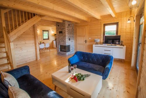 a living room with a blue couch and a table at Bieszczadzka Zatoka in Zawóz