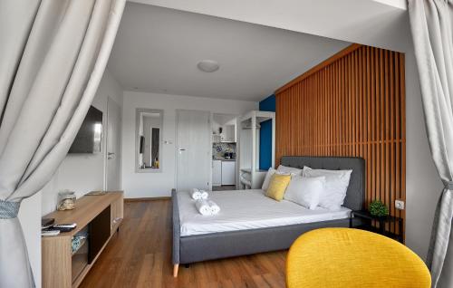 a bedroom with a bed and a yellow chair at Adel Apartments in Veliko Tŭrnovo