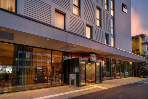 an exterior view of a building with glass doors at Holiday Inn - the niu, Fury Aschheim Messe by IHG in Aschheim