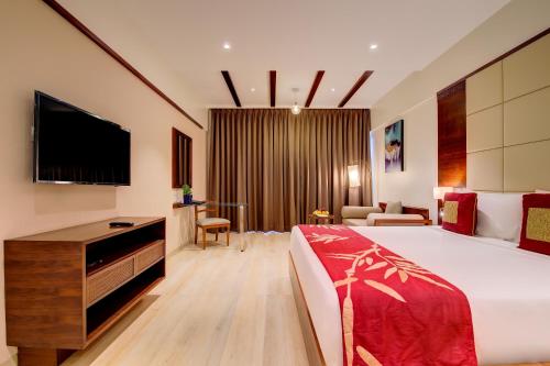 a hotel room with a bed and a flat screen tv at The Fern An Ecotel Hotel, Lonavala in Lonavala