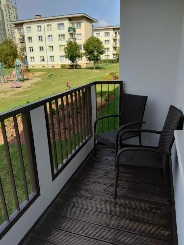 a balcony with two chairs and a playground at Apartament Pogodno in Szczecin