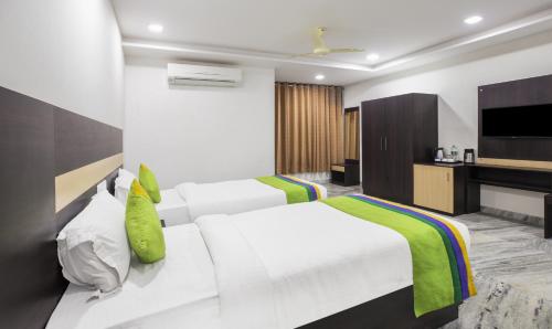 a bedroom with two beds and a flat screen tv at Hotel Royal Dezire Udaipur in Udaipur