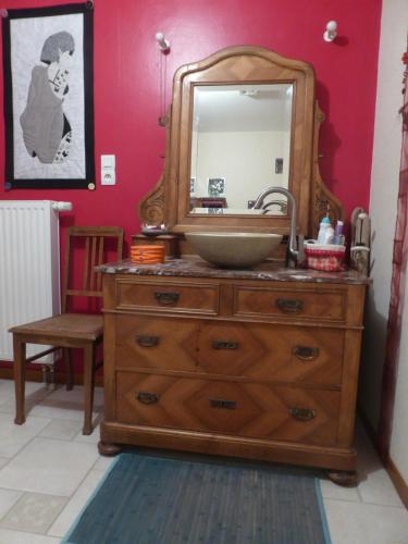 La salle de bains est pourvue d'un lavabo et d'un miroir sur une commode. dans l'établissement La Chambre de Manon, à Saint-Maurice