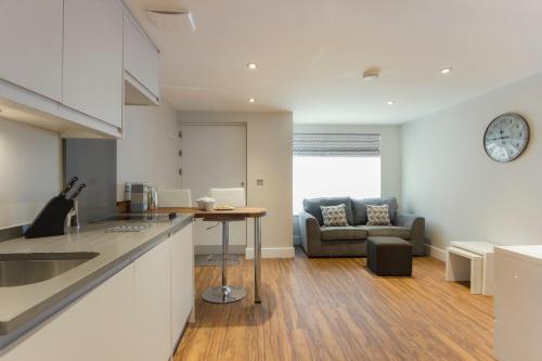 a kitchen and living room with a table and a couch at Citystay Living - The Dales in Cambridge