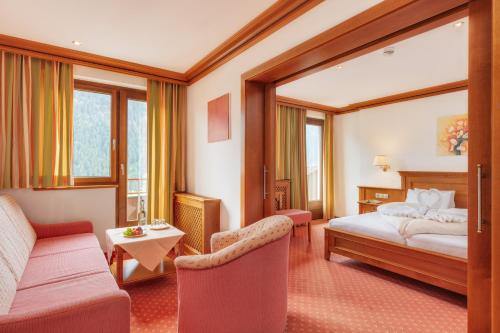 a hotel room with a bed and a couch at Berg-Spa & Hotel Zamangspitze in Sankt Gallenkirch