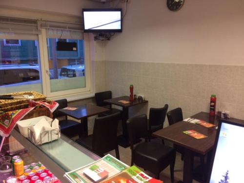 um restaurante com mesas e cadeiras e uma televisão na parede em Guest House Amsterdam em Amsterdã