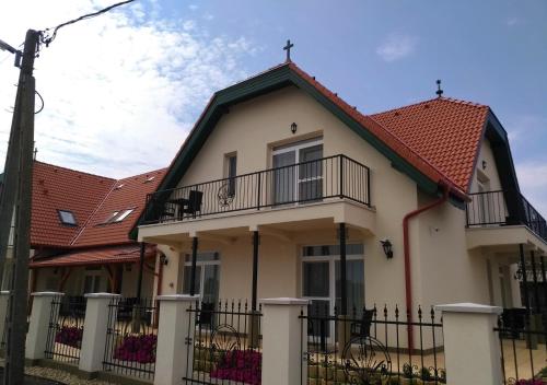 a house with a balcony and a fence at St. Hubert Vendégház in Hortobágy