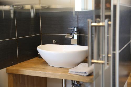 a bathroom with a white sink on a wooden counter at La Maison de Jules in Paray-le-Monial