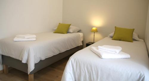 - 2 lits avec des oreillers verts dans une chambre dans l'établissement La Maison de Jules, à Paray-le-Monial