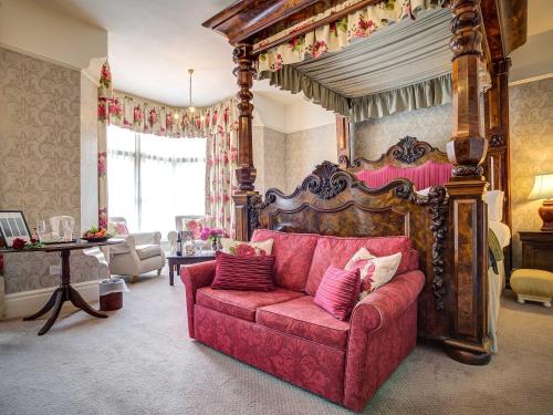 una sala de estar con un sofá rojo en una habitación en The Speech House, en Coleford