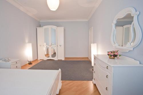 a white room with a vanity and a mirror at SutkiMinsk Apartment Centre in Minsk
