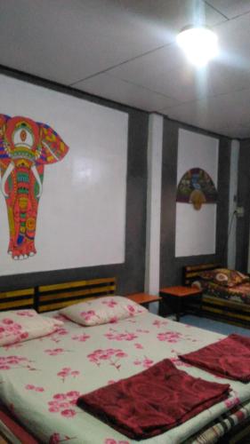 a bedroom with a bed with an elephant on the wall at The Kong in Bangkok
