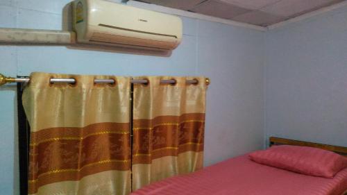 a bedroom with a curtain and a air conditioner on the wall at The Kong in Bangkok