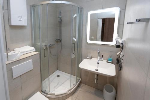 a bathroom with a glass shower and a sink at Hotel Prinz Anton in Düsseldorf