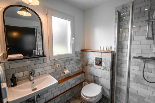 a bathroom with a sink and a toilet and a mirror at Frost and Fire Hotel in Hveragerði