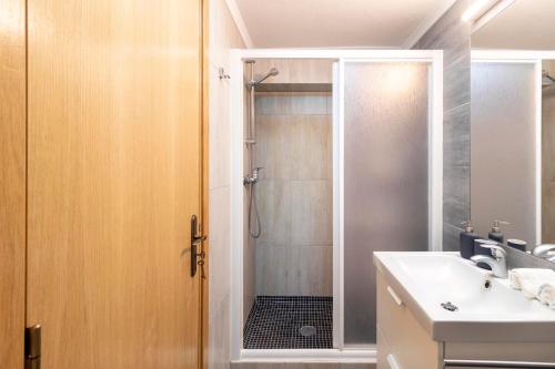 a bathroom with a shower and a sink at Casinha da Lurdes in Sesimbra