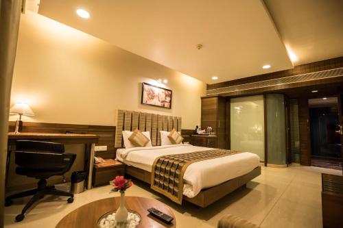 a hotel room with a bed and a desk at Bizz The Hotel in Rajkot
