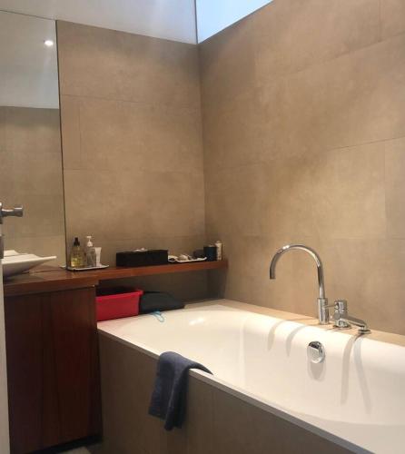 La salle de bains est pourvue d'une baignoire avec un lavabo et un miroir. dans l'établissement Cosy apartment in Paris center, à Paris