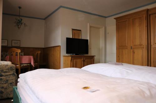 a hotel room with two beds and a flat screen tv at Gästehaus Blaue Ecke in Adenau