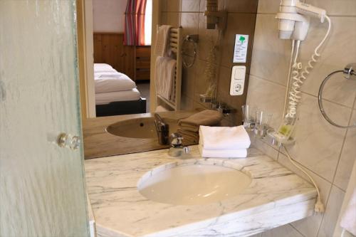 a bathroom with a sink and a mirror at Gästehaus Blaue Ecke in Adenau