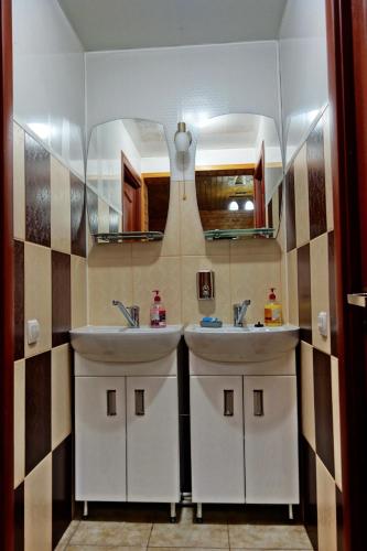 two sinks in a bathroom with two mirrors at Рада Дараба in Krasnik