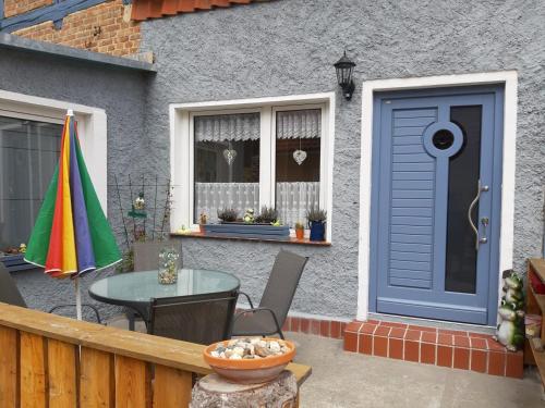 una casa con una puerta azul y una mesa en Villa Windschief, en Thale