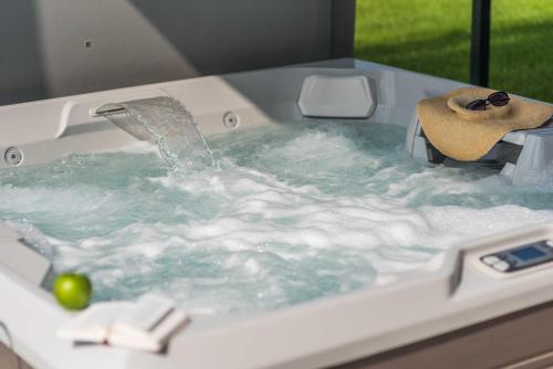a bath tub filled with water with a sink at Luxus_SPA_EG_Fewo AQUAMARIN _WE 1_ in Göhren-Lebbin