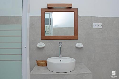 y baño con lavabo blanco y espejo. en Villa Perpetua, en Bandarawela