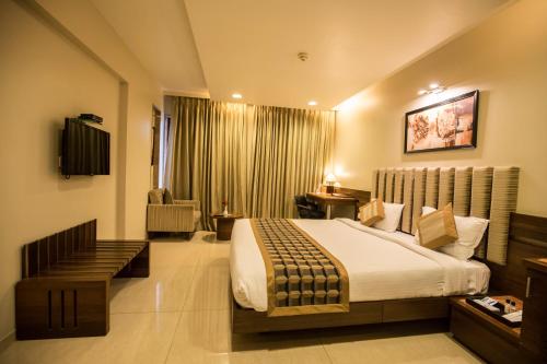 a bedroom with a large bed in a room at Bizz The Hotel in Rajkot