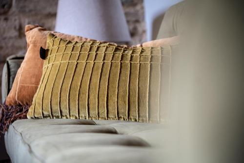 a person putting a pillow on a couch at Borgo Castello Panicaglia in Nocera Umbra