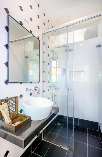 a bathroom with a sink and a glass shower at Areca Hotel Penang in George Town