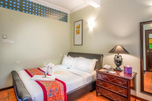a bedroom with a bed and a table with a telephone at Areca Hotel Penang in George Town
