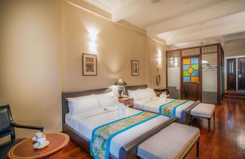 a hotel room with two beds and a tv at Areca Hotel Penang in George Town