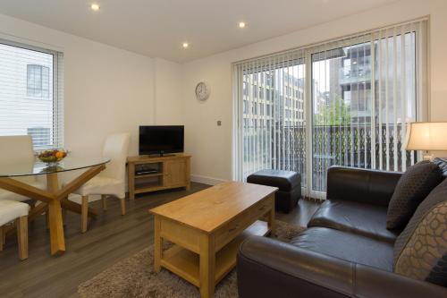a living room with a couch and a table at Citystay Living - Mill Park Apartments in Cambridge