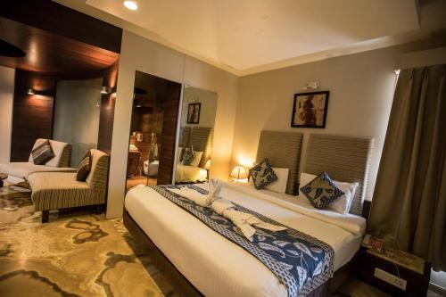 a bedroom with a large bed in a room at Bizz The Hotel in Rajkot