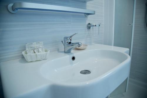 lavabo blanco en el baño con espejo en Hotel Etoile, en Rímini