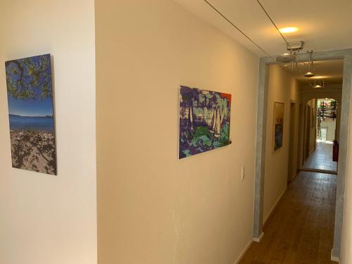 a hallway with three paintings on the walls at Gästehaus am See in Gaienhofen