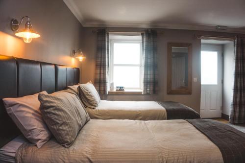Bowmore的住宿－THE BRUCE，一间带两张床和一张沙发的卧室