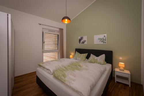 a bedroom with a large bed with a window at Ferienhäuser Immenhöfe in Donaueschingen