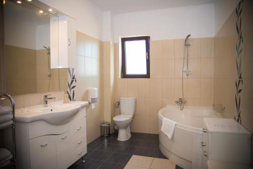 a bathroom with a sink and a tub and a toilet at Hotel Stefani in Sibiu