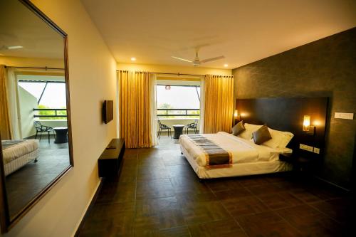 a hotel room with a bed and a large mirror at Avoki Resorts in Trivandrum
