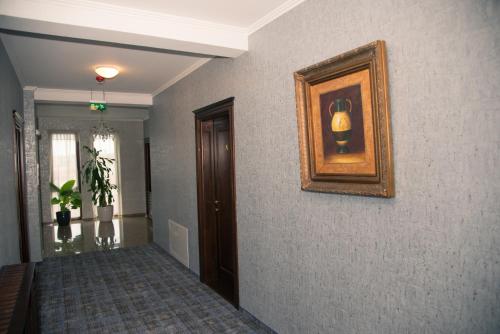 a hallway with a painting on the wall and a hallway sidx sidx sidx at Hotel Stefani in Sibiu