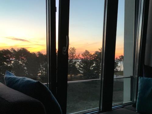 an open window with a view of a sunset at Inselloft Rügen - Meerblick, Pool & eigener Strandzugang in Binz