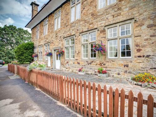 a brick building with flowers in front of it at The Speech House in Coleford