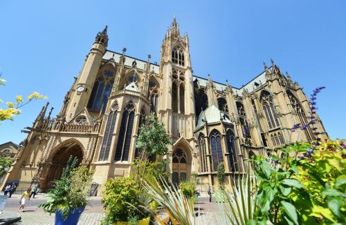 a large cathedral with a tall building with a tower at Mercure Grand Hôtel Metz Centre Cathédrale in Metz