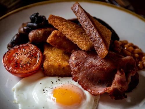 a plate of breakfast food with eggs bacon and beans at The Speech House in Coleford